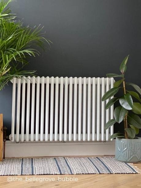 a white horizontal radiator on a blue wall