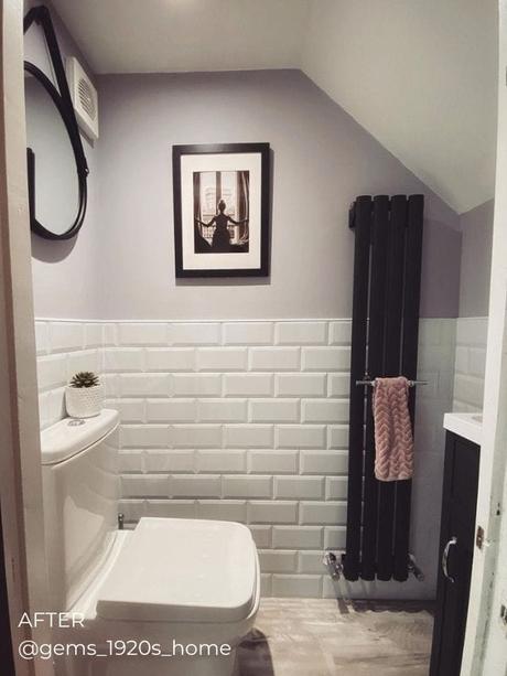 vertical black designer radiator in a white modern bathroom