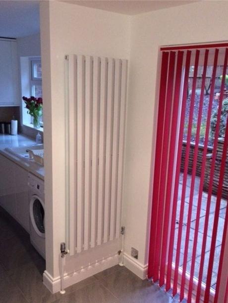 Milano Viti white vertical radiator near red back exit of a house