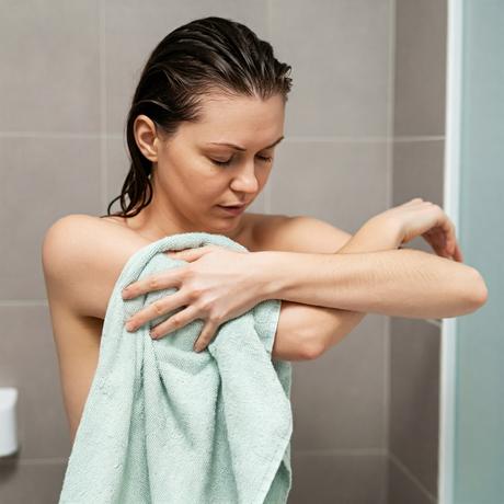 Woman drying her skin with a towel to prevent fungal infections