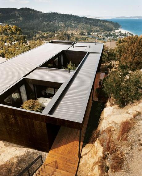 Modern hillside home with stained plywood cladding