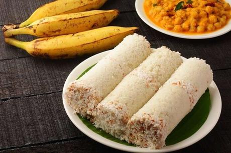 Kerala-style Puttu served with Kadala Curry, ripe bananas, and garnished with a green banana leaf