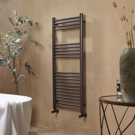 Milano Esk gun metal gray heated towel rail on beige wall in modern bathroom