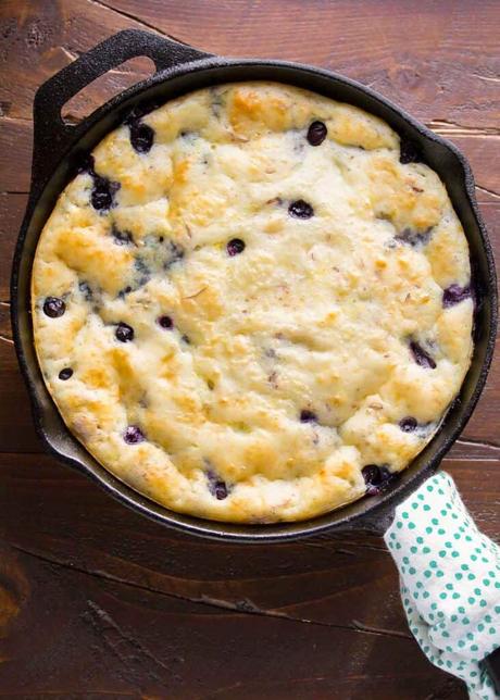 an unsliced deep dish pancake in a cast iron skillet