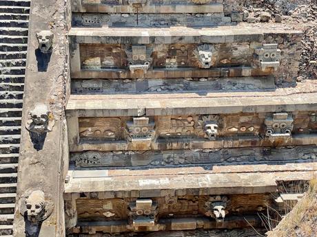 Close-up of intricate stone carvings of feathered serpent heads and geometric patterns along the steps of the Temple of the Feathered Serpent at Teotihuacan.