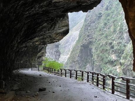 A rocky path carved into the cliffs of Taroko Gorge, offering a view of the lush green valley beyond.