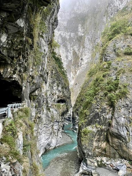 A dramatic view of Taroko Gorge's steep cliffs, with a turquoise river winding through the base.