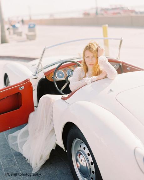 wedding trasportation bride posing in white retro wedding car