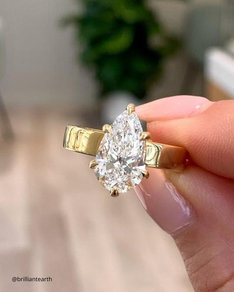 The Heart of an Ethical Promise: More Than Just a Ring ethical engagement rings yellow gold ring with pear shaped diamond close up photo brilliantearth