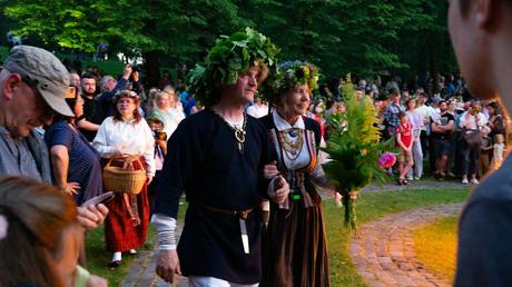 20 Best Places to Visit in Latvia people in traditional costumes with wreaths of leaves on their heads at a ligo or midsummer celebration
