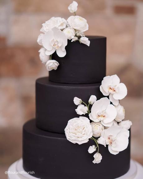 The Ultimate Guide to Using Fake Flowers for Your Wedding fake flowers black three tier wedding cake with white fake latex orchids