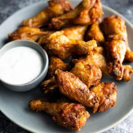gray plate with pile of air fryer chicken wings and dipping sauce