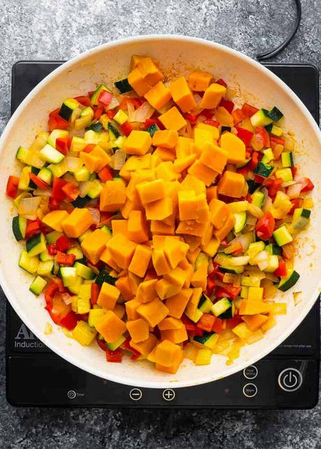 Vegetarian Enchiladas cooked vegetables and sweet potatoes in a skillet