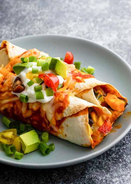 Vegetarian Enchiladas A plate of vegetarian enchiladas topped with avocado and sour cream