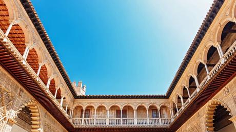 Our 4 Favorite Europe Destination Pairings Things to do in Spain - Palace of Alcazar, Famous Andalusian Architecture. Old Arab Palace in Seville, Spain. Ornamented Arch and Column. Famous travel destination.