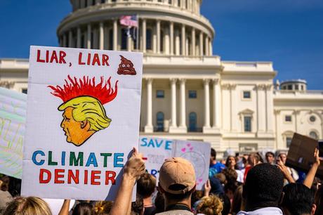 Trump’s asinine war on climate science is pushing us into a dystopian future A person holding up a sign mocking President Trump during a climate protest at the White House in Washington D.C.