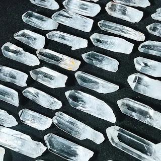 Natural clear quartz rough point specimen on granite surface Natural clear quartz rough point specimen on granite surface