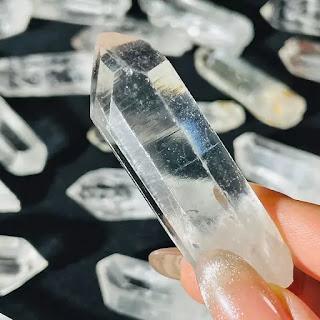 Natural clear quartz rough point specimen on granite surface Natural clear quartz rough point specimen on granite surface