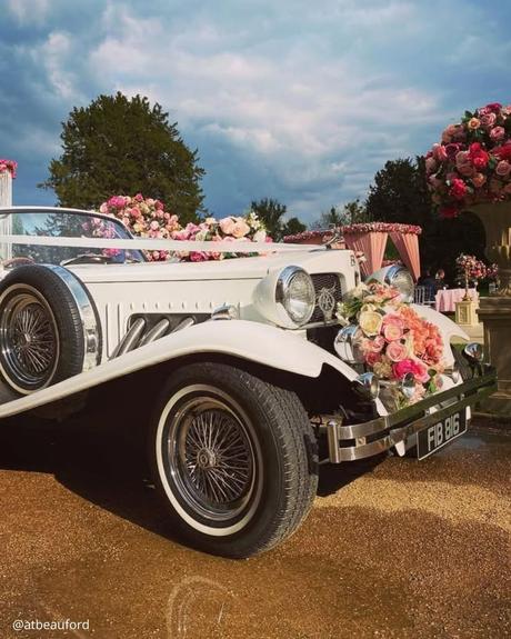 wedding car hire london white retro premium car with round headlights decorated with pink hued flowers latbeauford