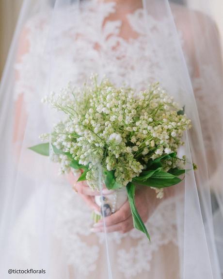 Everything You Need to Know About Lily of the Valley Bouquets lily of the valey wedding bouquet bride covered by veik with the bouquet tictockflorals