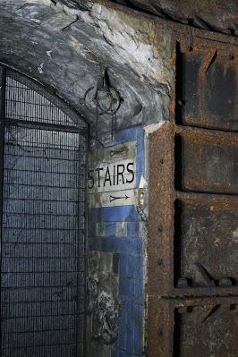 Hidden signs of Green Park station A tiled sign in the side of an archway says 'STAIRS', with an arrow below.