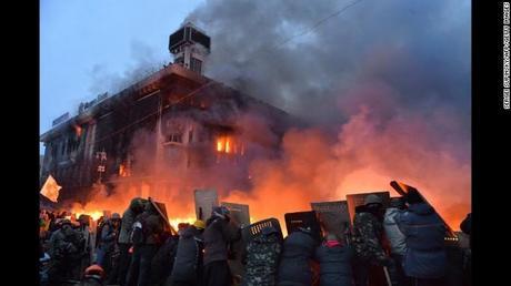 Protesters protect themselves with shields as they clash with police in Kiev on February 19.