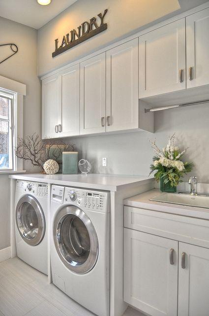 I would love to have an organized laundry room like this some day.  Love the cabinets for Laundry storage, and the area above laundry machines, much more usable!! :)