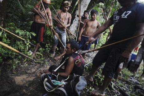 Munduruku Indian warriors stand guard over an illegal gold miner who was detained by a group of warriors searching out illegal gold mines and miners in their territory near the Caburua river, a tributary of the Tapajos and Amazon rivers in western Para state January 20, 2014. REUTERS/Lunae Parracho