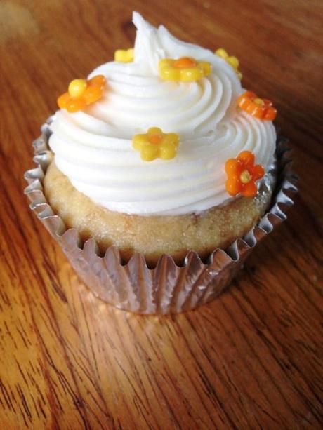 banan cupcake with salted caramel buttercream swirl frosting and flower past fondant orange and yello