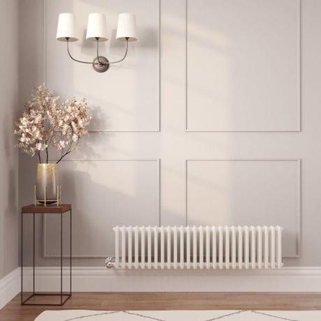 The 10 best column radiators for traditional and modern homes Milano Windsor white traditional horizontal electric triple column radiator on light wall nearby table with gold vase beneath triple light fitting