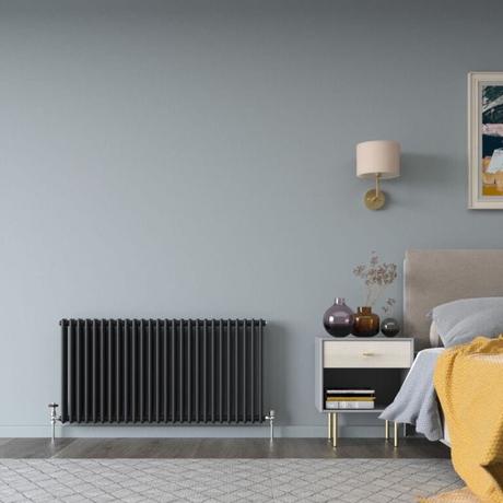 The 10 best column radiators for traditional and modern homes Milano Windsor black horizontal traditional double column radiator on light blue wall nearby bedside table and lamp and bed beneath artwork