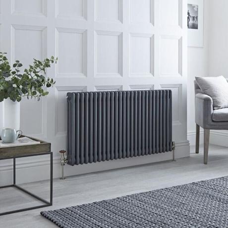 The 10 best column radiators for traditional and modern homes Milano Windsor anthracite traditional triple column radiator on white background nearby gray chair and table with vase