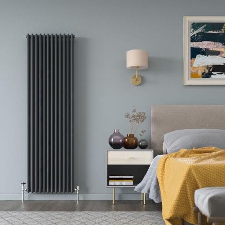 The 10 best column radiators for traditional and modern homes Milano Windsor anthracite traditional vertical triple column radiator on light blue wall in modern bedroom nearby bedside table and lamp and bed underneath artwork