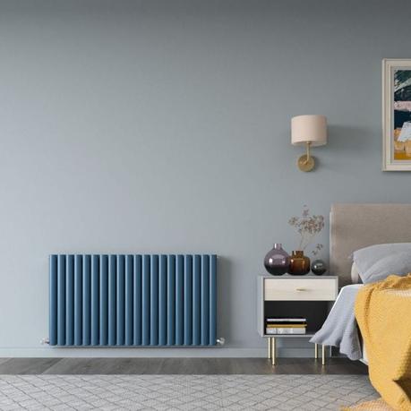 A blue designer radiator in a modern bedroom setting
