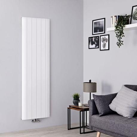 Why does my radiator keep turning off? Milano Skye white aluminum vertical designer radiator on light wall nearby multiple pictures and shelf above gray settee