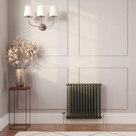 A guide to radiator repair and replacement costs Milano Windsor green horizontal traditional double column radiator on light wall nearby small table with gold vase and fake gold plant beneath triple lamp fitting