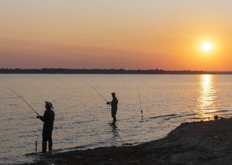 Two men fishing at sunrise on Lavon Lake near Dallas, Texas