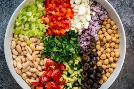an overhead shot of dense bean salad in a large white bowl