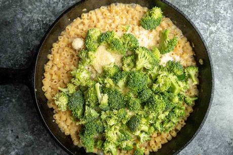 Broccoli Pasta broccoli, butter and parmesan with cooked pasta in a black skillet