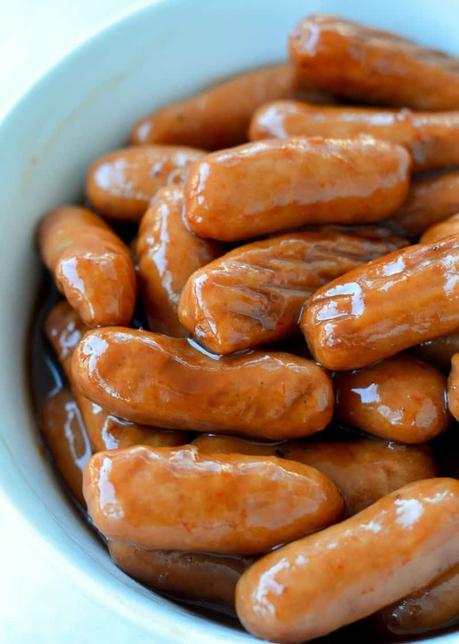 15+ Holiday Slow Cooker Recipes close up image of lil smokies in a white bowl