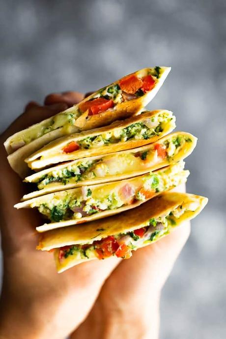 hand holding a stack of spinach and feta breakfast quesadilla slices