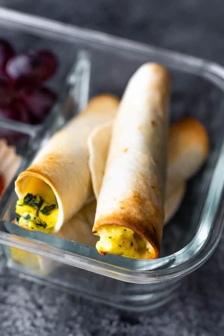 Three breakfast taquitos in a glass meal prep container