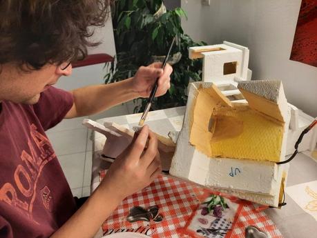 Making a Nativity diorama inside an antique steamer trunk: the first touch of color on the buildings