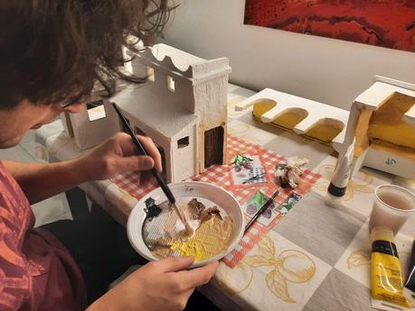 Making a Nativity diorama inside an antique steamer trunk: the first touch of color on the buildings
