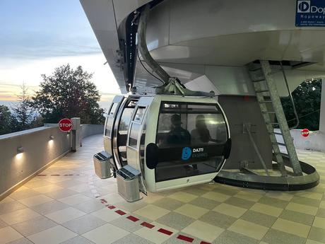 Modern Dajti Ekspres cable car at the upper station near Tirana, with passengers seated inside ready to descend the mountain. A scenic and comfortable way to reach Mount Dajti for panoramic views of the Albanian capital.