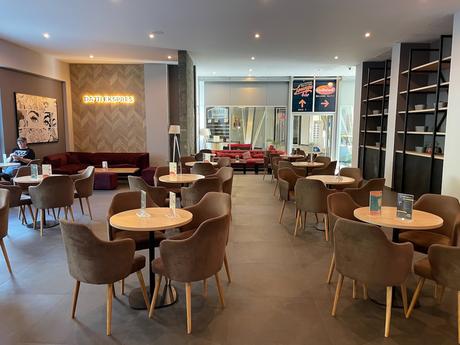 Interior of the Dajti Ekspres café with neatly arranged tables, soft brown chairs, and modern décor. A relaxing spot to enjoy a drink before or after a cable car ride to Mount Dajti.