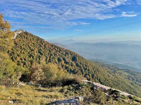 View of Mount Dajti’s forested slopes and summit antenna under a bright blue sky, taken from the Mount Tujanit trail. A sweeping panorama showing the rugged terrain and autumn colours near Tirana.