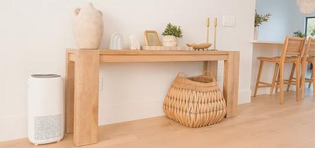 Clean air purifier next to a wooden console table in a modern, minimalistic home interior.