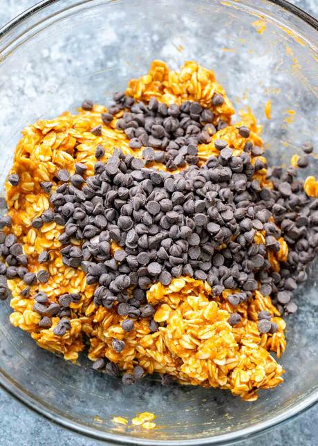 chocolate chips being added to pumpkin spice cookie mixture