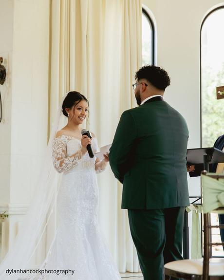 An Emerald & Sage, Zero-Alcohol Real Wedding a bride recites her vows to the groom using a microphone dylanhancockphotography